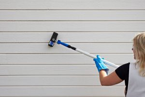 Dame skrubber hus vasket med Jotun husvask